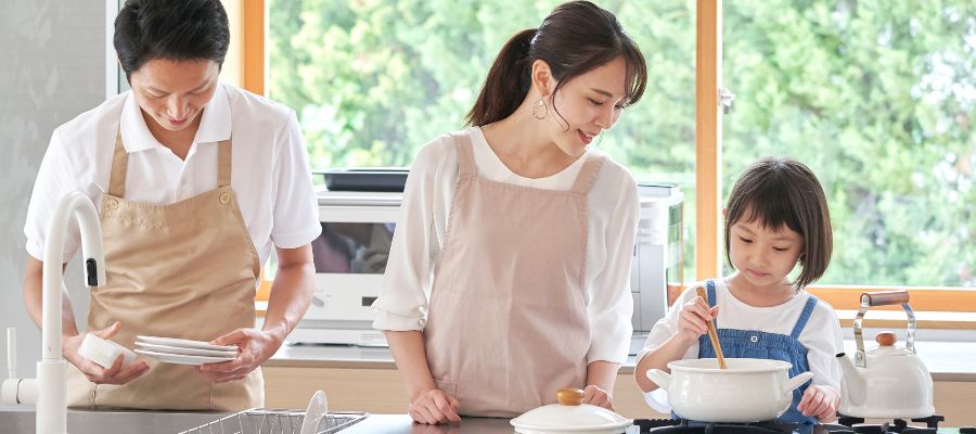 キッチンで料理する家族写真