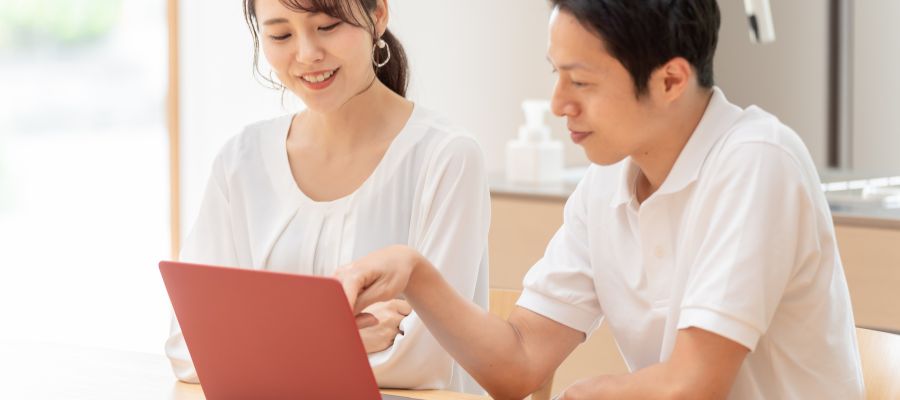 パソコンで問い合わせフォームに入力中の夫婦の写真