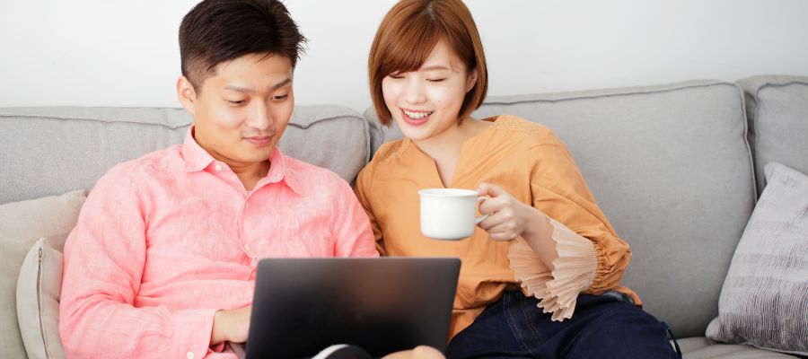 パソコンで問い合わせフォームに入力中の夫婦の写真