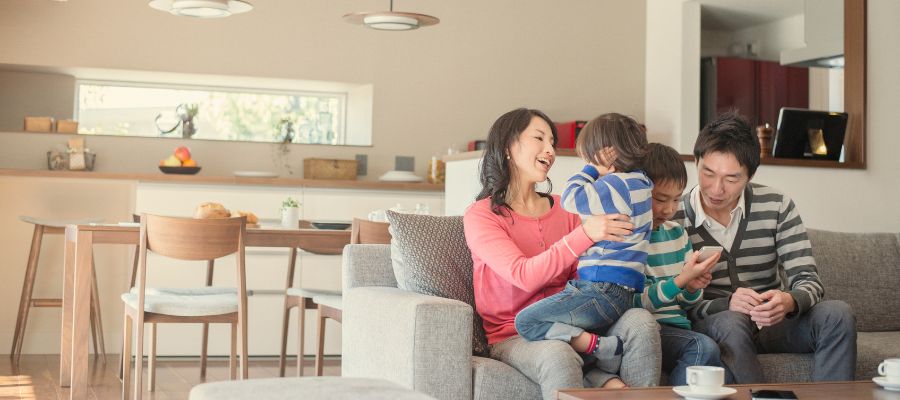 家のリビングルームでくつろいでいる家族写真